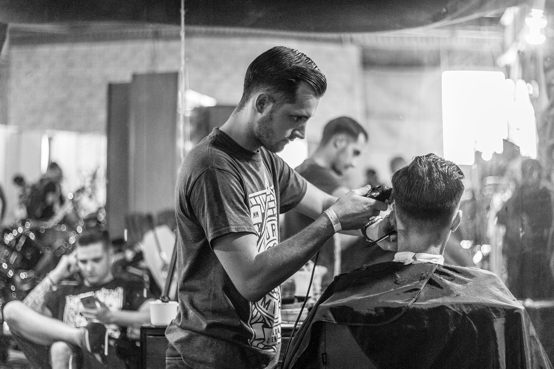 A barber at work inside Old School Barbers, Tauranga