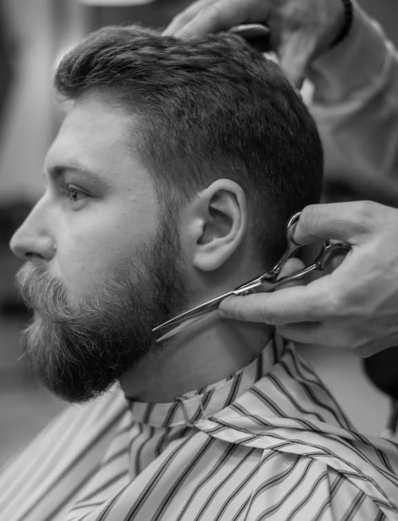 A barber blending a fade with clippers