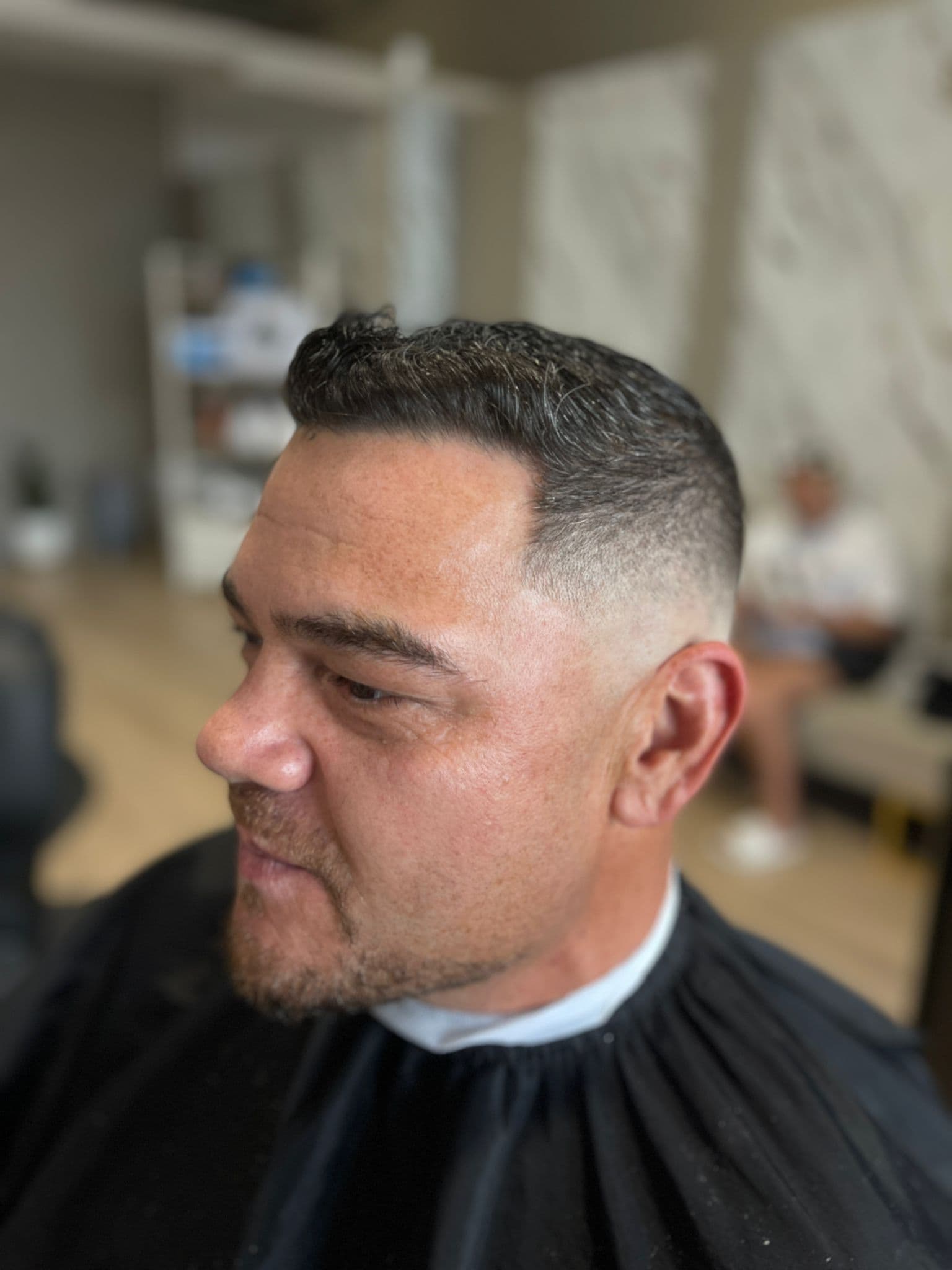 Skin fade with a classic standard cut on top, front view