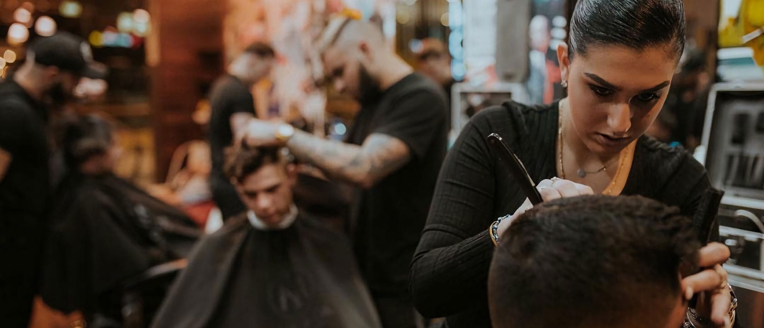 A barber finishing a fade at Old School Barbers in Tauranga